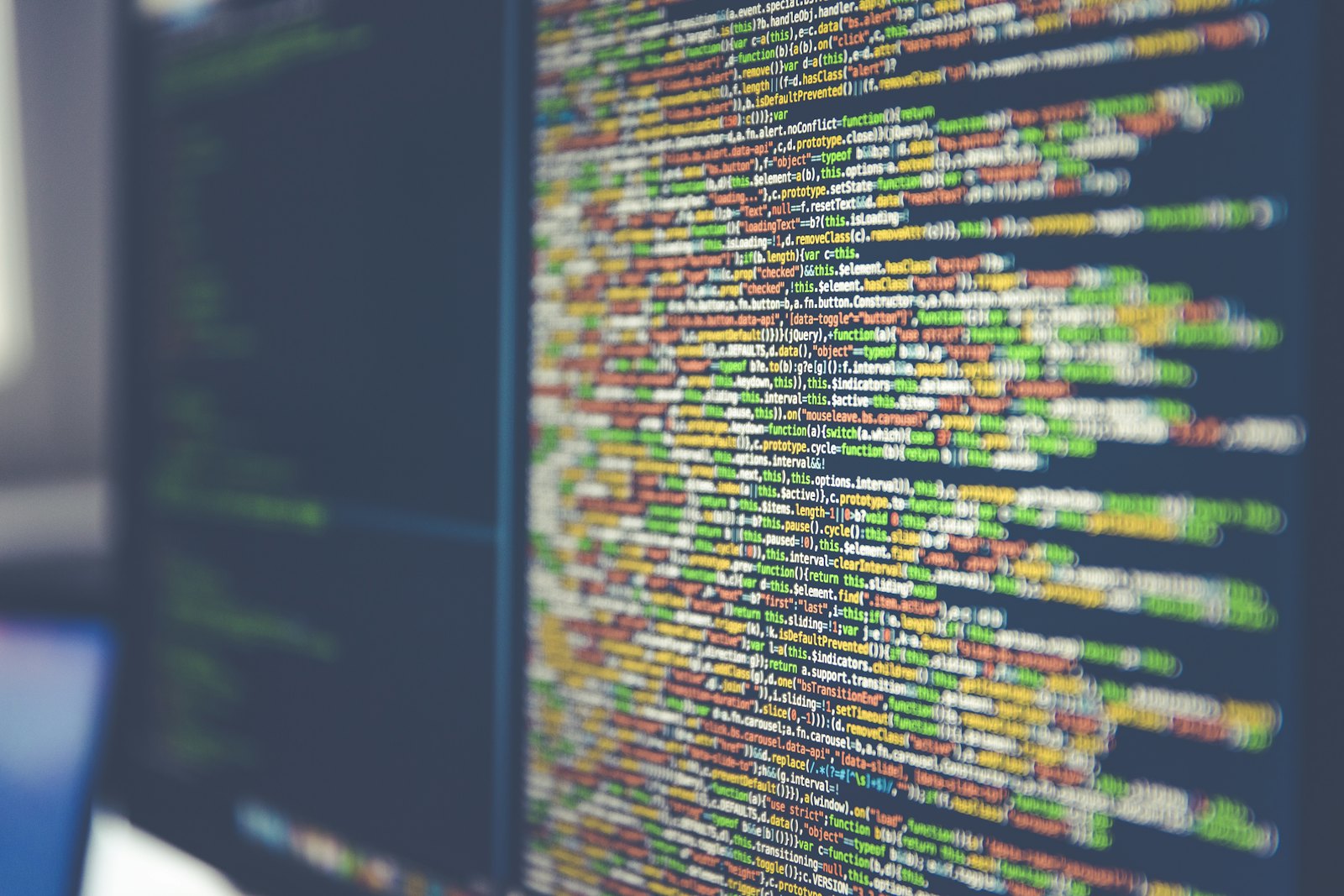 Close-up of a dark code editor screen showing colorful syntax-highlighted code and a diff view